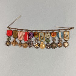 BARRETTE DE 11 REDUCTIONS DES MEDAILLES MILITAIRES D'UN ANCIEN DE LA PREMIERE GUERRE ET DES COLONIES